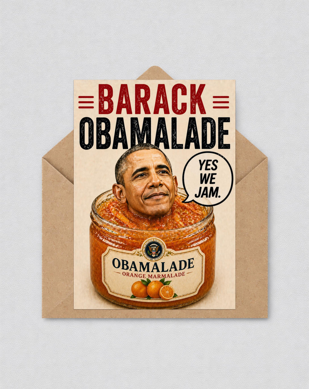 May include: A novelty greeting card with a humorous design. The card shows Barack Obama's head in a jar of orange marmalade, with the words "BARACK OBAMALADE" and a speech bubble saying "YES WE JAM."