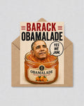 May include: A novelty greeting card with a humorous design. The card shows Barack Obama's head in a jar of orange marmalade, with the words "BARACK OBAMALADE" and a speech bubble saying "YES WE JAM."