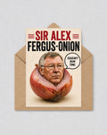 May include: A humorous greeting card with a picture of a man's face inside a red onion. The card reads "SIR ALEX FERGUS-ONION" in red and black text. A speech bubble says "SQUEAKY BUM TIME."