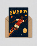 May include: Greeting card with a cartoon illustration of a footballer in a red and white kit, flying through space. The words "STAR BOY" are in yellow. The card is inside a brown envelope.