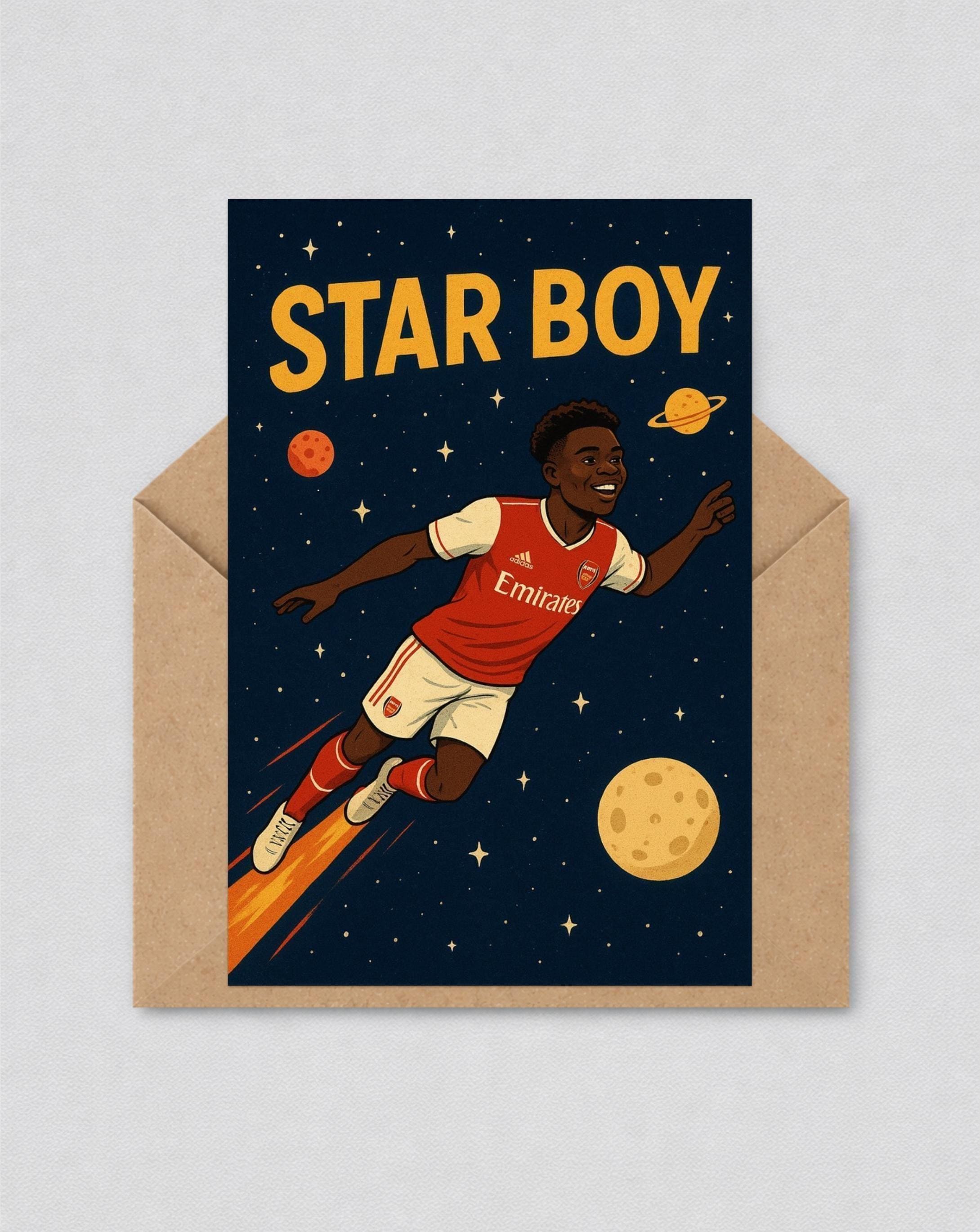 May include: Greeting card with a cartoon illustration of a footballer in a red and white kit, flying through space. The words "STAR BOY" are in yellow. The card is inside a brown envelope.