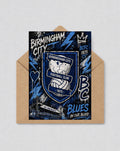 May include: A greeting card with the Birmingham City Football Club crest in blue and white, with the text "Birmingham City" and "Blues in our blood." The card is inside a brown envelope. The design includes lightning bolts and a crown.