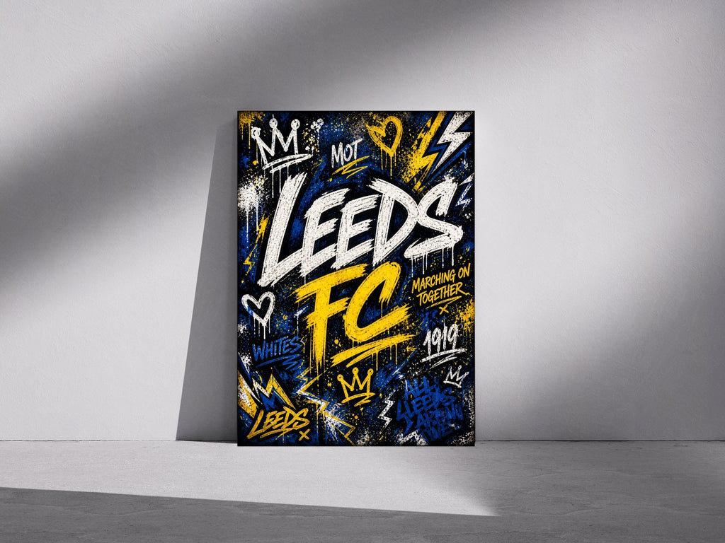 May include: A framed art print with a graffiti-style design. The artwork features the words "Leeds FC" in white and yellow, with additional text and symbols in blue and yellow. The background is black.
