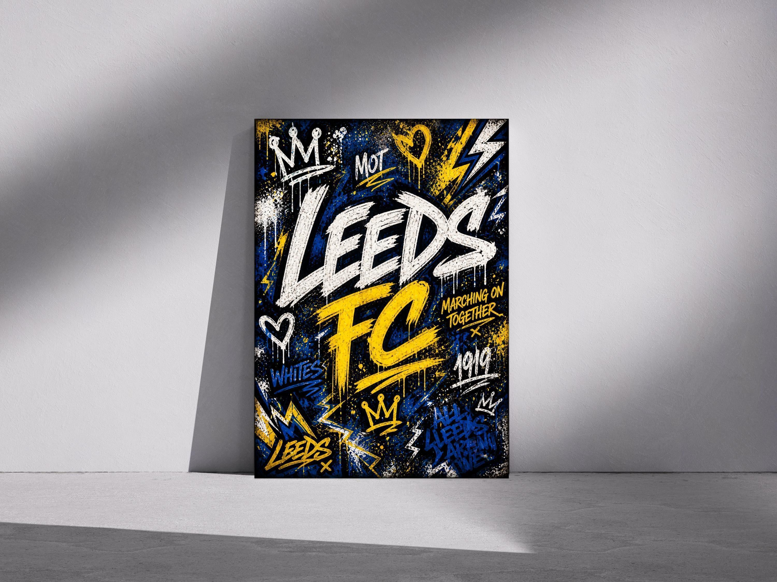 May include: A framed art print with a graffiti-style design. The artwork features the words "Leeds FC" in white and yellow, with additional text and symbols in blue and yellow. The background is black.